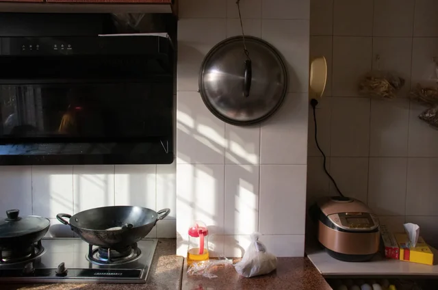 Uredni lonci i ekspres lonac u modernoj kuhinji, uz drvenu dasku, lanenu krpu i svježe namirnice.